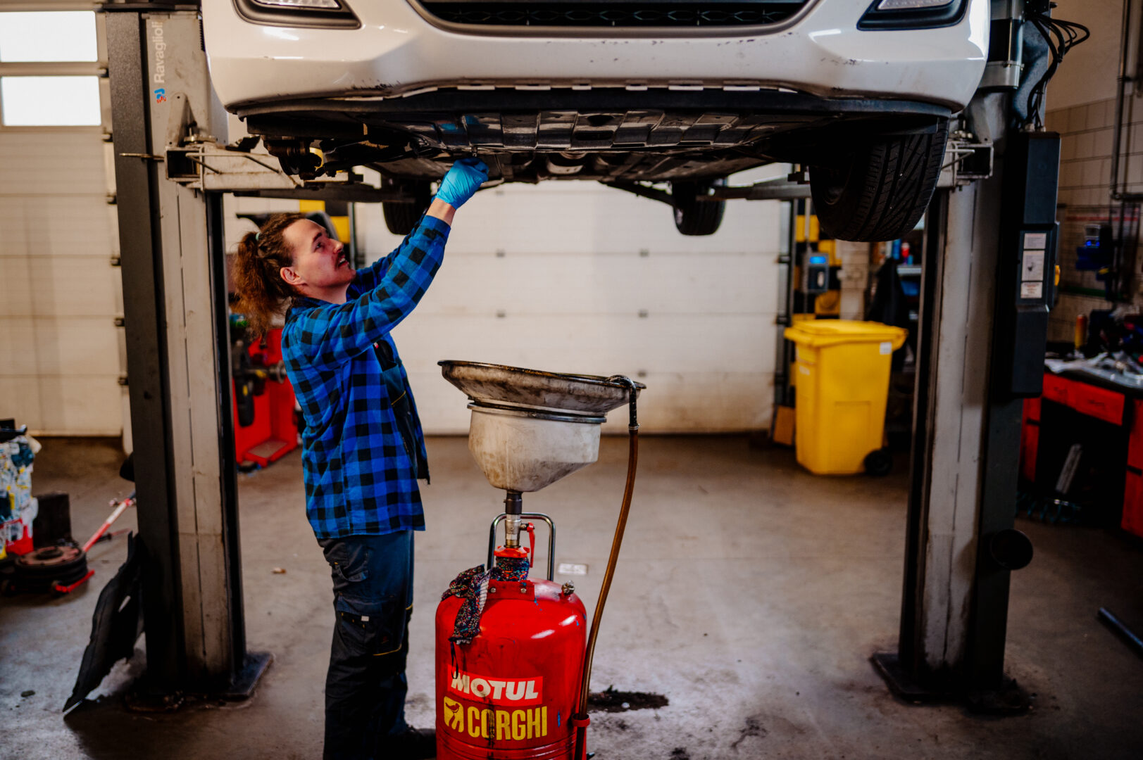 serwis olejowy samochodu mechanik wymieniający stary olej silnikowy