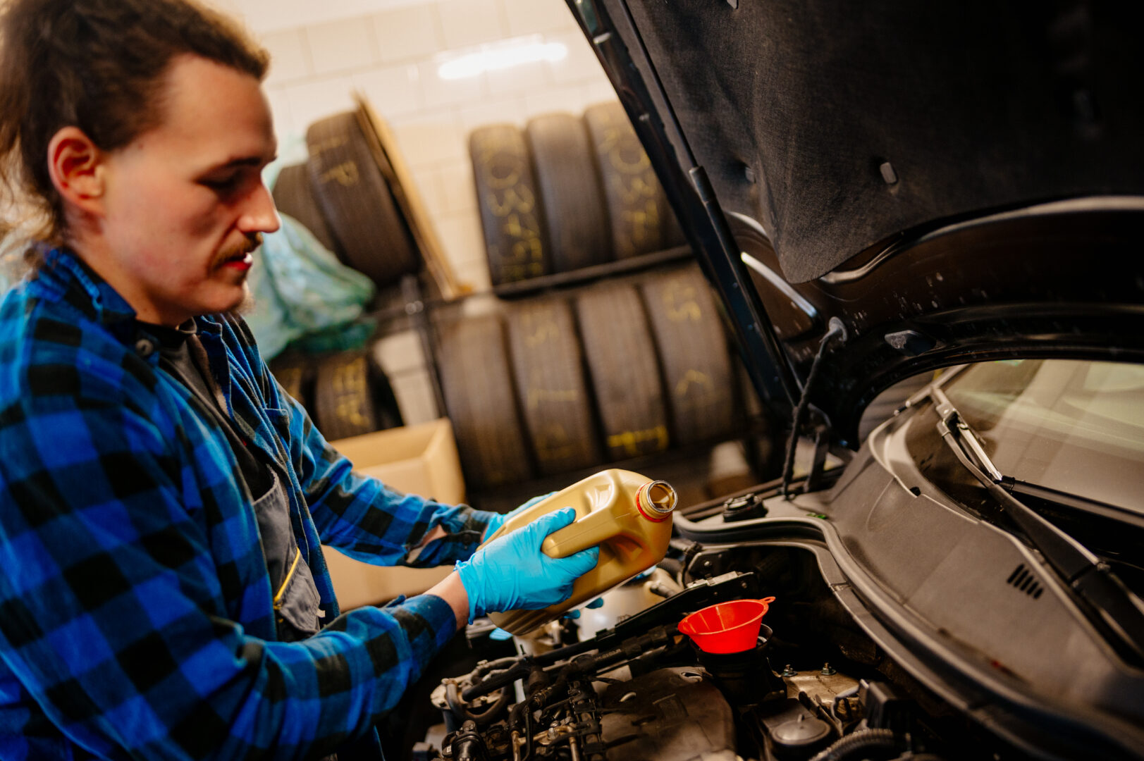 uzupełnianie oleju silnikowego mechanik uzupełniający olej silnikowy