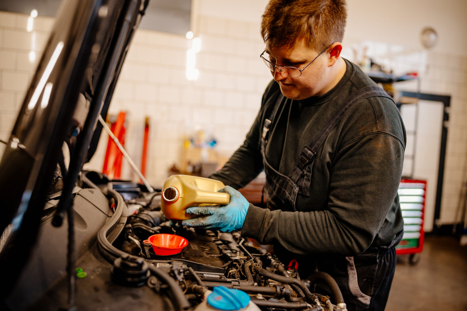 serwis olejowy mechanik dolewający olej silnikowy